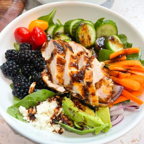 Blackberry grilled chicken salad with blackberry balsamic chili lime dressing in a white bowl