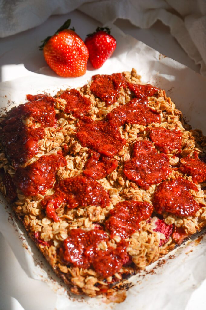 Full overhead view of healthy strawberry chia jam oat squares with homemade strawberry chia jam covering the golden oat crumble top
