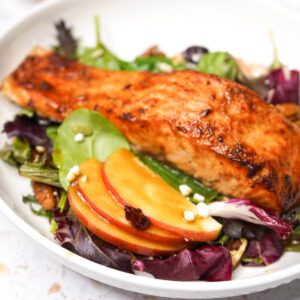 Glazed air fryer maple balsamic salmon served over fresh seasonal salad greens.