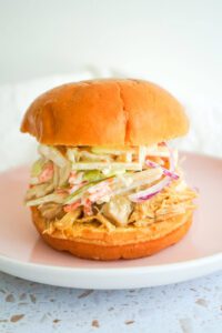 Juicy apple cider pulled chicken sandwich topped with creamy apple slaw on a brioche bun.