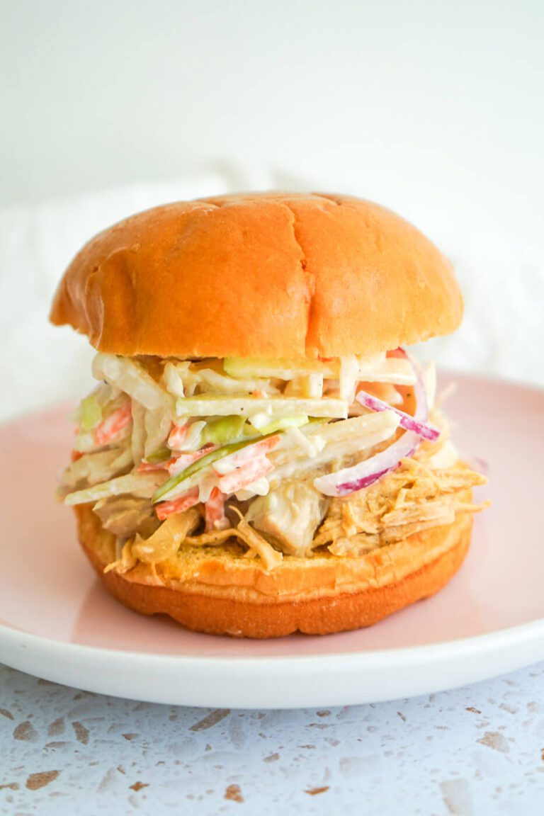 Juicy apple cider pulled chicken sandwich topped with creamy apple slaw on a brioche bun.